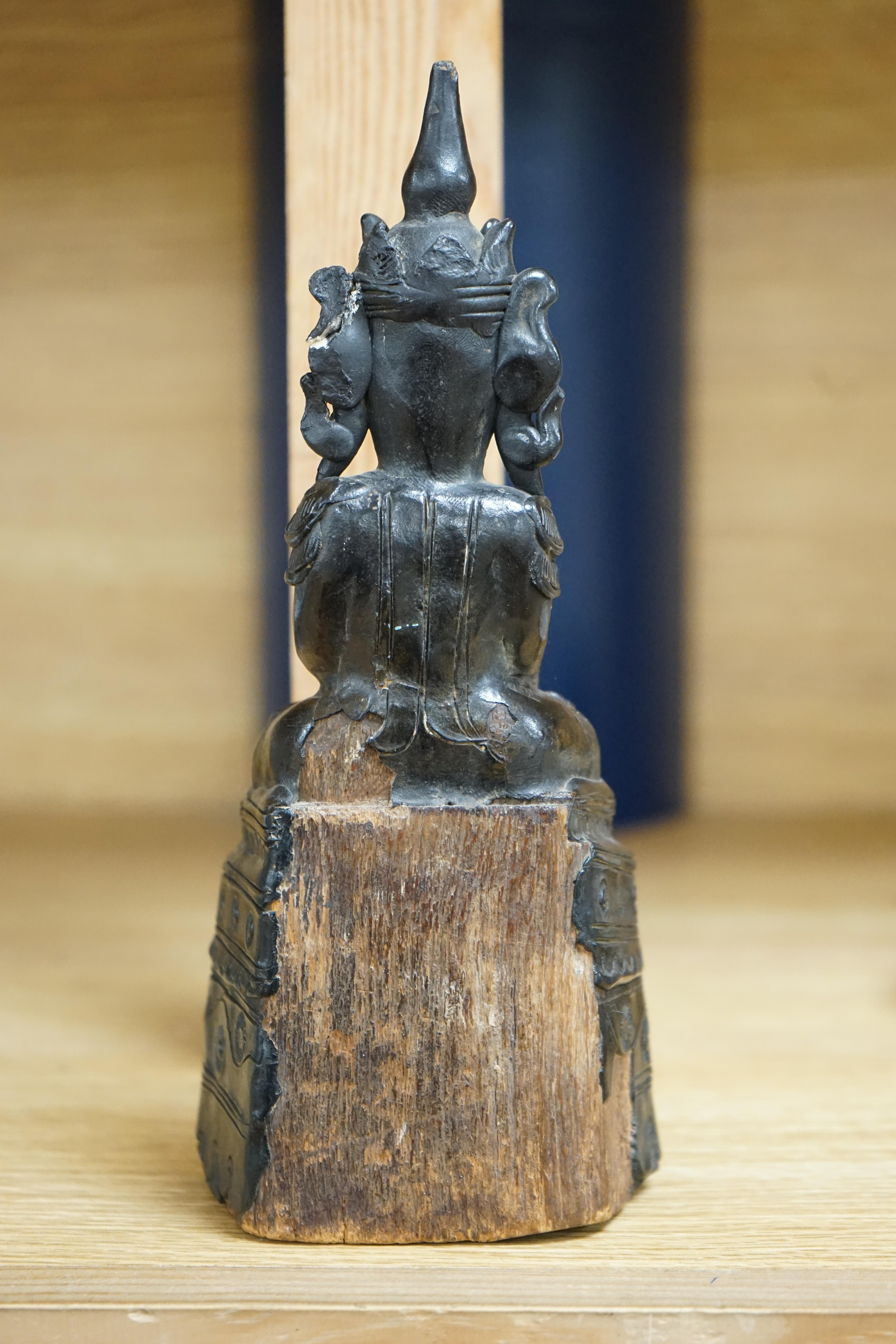 A 19th century Burmese black lacquer and wood seated figure of Buddha, 21cm high. Condition - fair, losses to the lacquer on the reverse